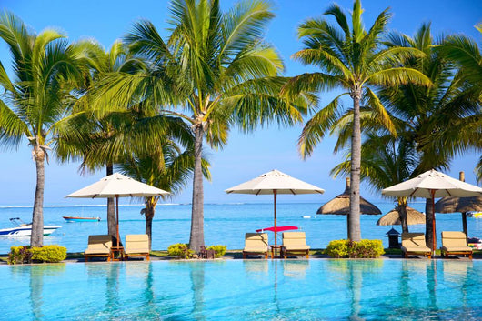 Swimming pool with  umbrellas on beach in Mauritius Wall Mural
