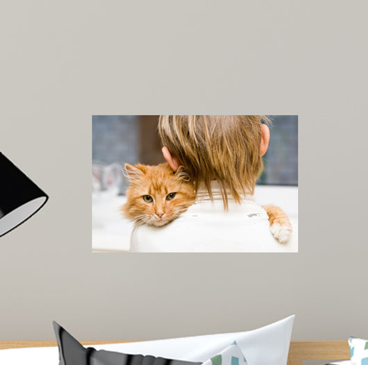 The red cat sitting on a shoulder at the child 