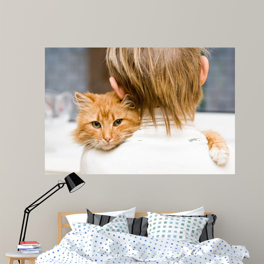 The red cat sitting on a shoulder at the child 