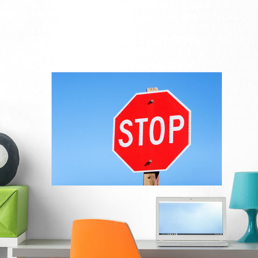 Stop sign on a road Wall Mural