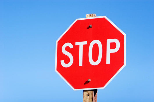 Stop sign on a road Wall Mural