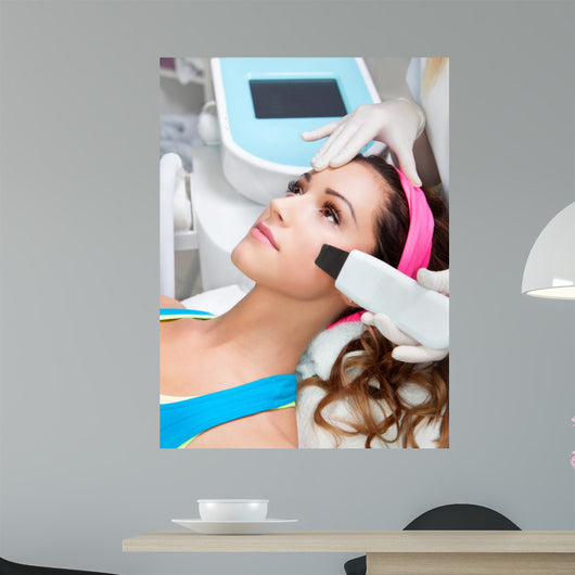 Woman getting laser face treatment in medical spa center 