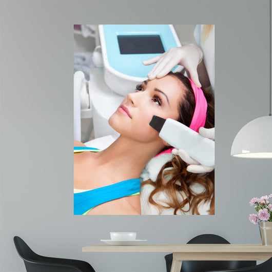 Woman getting laser face treatment in medical spa center 