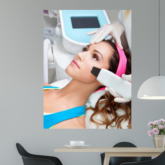 Woman getting laser face treatment in medical spa center 