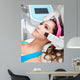Woman getting laser face treatment in medical spa center 