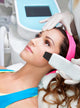 Woman getting laser face treatment in medical spa center 