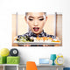 Beautiful young woman eating sushi. Shallow depth of field, focu 