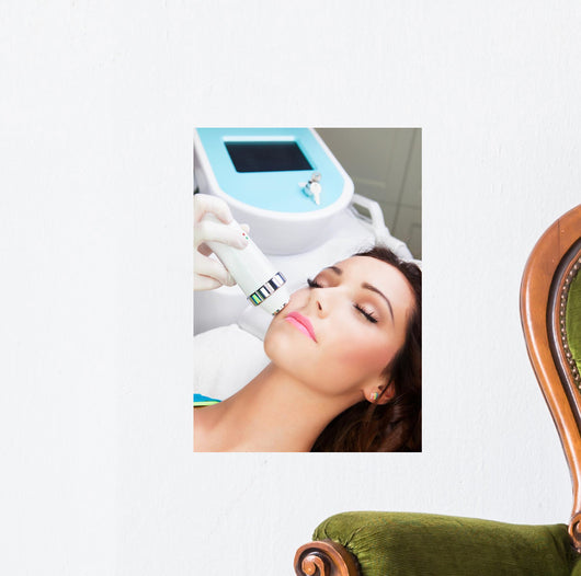 Woman getting laser face treatment in medical spa center 