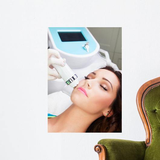 Woman getting laser face treatment in medical spa center 