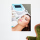 Woman getting laser face treatment in medical spa center 