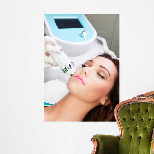 Woman getting laser face treatment in medical spa center 