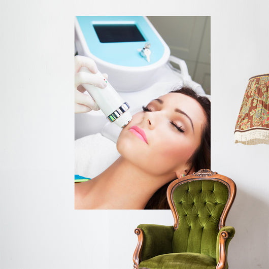 Woman getting laser face treatment in medical spa center 