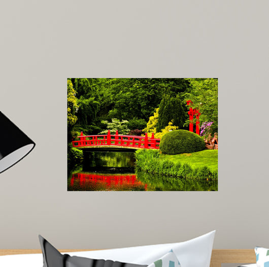 Red Bridge over a Lake in Green Japanese Garden 
