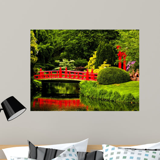 Red Bridge over a Lake in Green Japanese Garden 