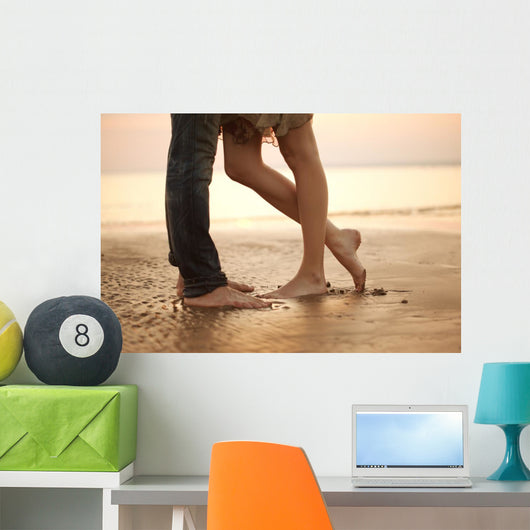 A loving young couple hugging and kissing on the beach. Lovers m Wall Mural