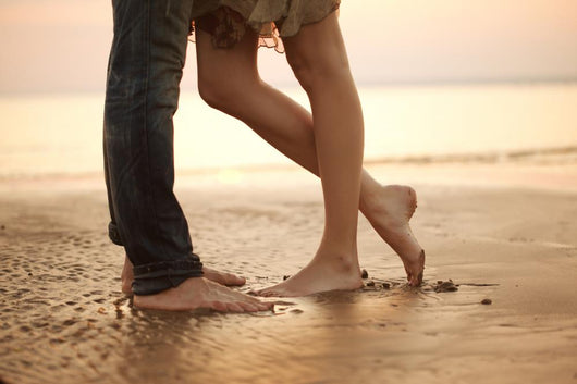 A loving young couple hugging and kissing on the beach. Lovers m Wall Mural