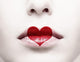 Close up of female lips with red heart shape painted on it 