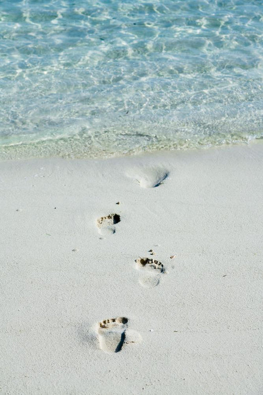 Footprints on a white beach 