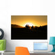 Silhouettes of tourists riding camels on dunes Wall Mural