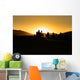 Silhouettes of tourists riding camels on dunes Wall Mural