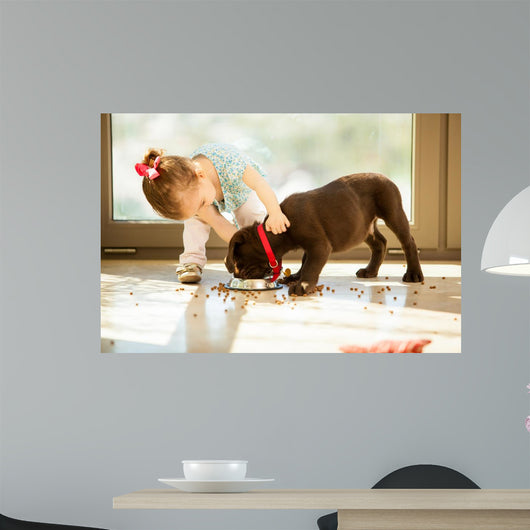 Cute little girl feeding her puppy 