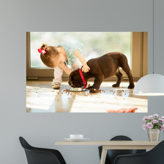 Cute little girl feeding her puppy 
