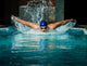 Muscular young man in blue cap in swimming pool 
