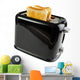 Black toaster with bread slices , isolated on white 