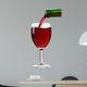 pouring red wine from the bottle into a glass 