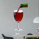 pouring red wine from the bottle into a glass 