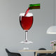 pouring red wine from the bottle into a glass 