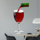 pouring red wine from the bottle into a glass 