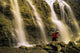 Time Delay Of Waterfall With Cyclist Carrying Bicycle Wall Mural