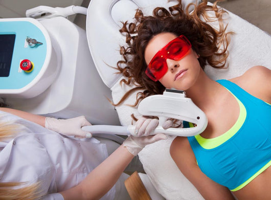 Woman getting laser face treatment in medical spa center 