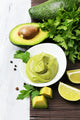 Fresh guacamole in bowl on wooden table 