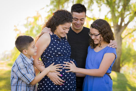 Hispanic Family Hands on Pregnant Mother Tummy Feeling Baby Kick 