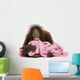 Young Bornean orangutan lying, cuddling a pink towel 