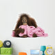 Young Bornean orangutan lying, cuddling a pink towel 