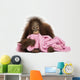 Young Bornean orangutan lying, cuddling a pink towel 
