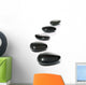 Five black pebbles in a gentle curve on a white surface Wall Mural