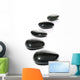Five black pebbles in a gentle curve on a white surface Wall Mural