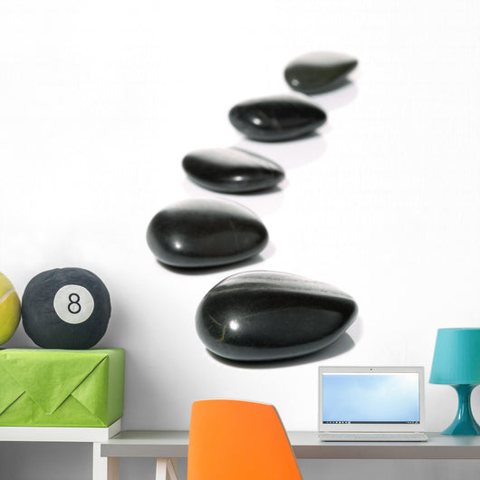Five black pebbles in a gentle curve on a white surface Wall Mural
