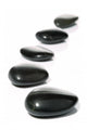 Five black pebbles in a gentle curve on a white surface Wall Mural