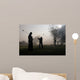Early morning golfers silhouetted in a dense fog 