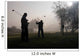 Early morning golfers silhouetted in a dense fog 