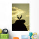 white storks on nest on rock at sunset Wall Mural