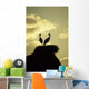 white storks on nest on rock at sunset Wall Mural