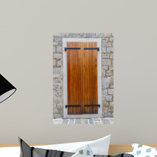 Large wooden shutters in a stone wall 