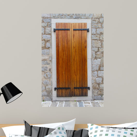 Large wooden shutters in a stone wall 