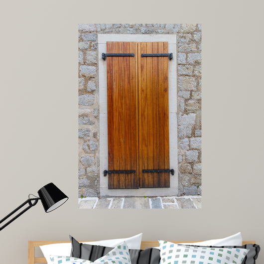 Large wooden shutters in a stone wall 